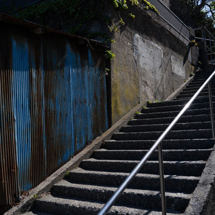 Back alley of Enoshima with stone steps and a blue corrugated metal sheet