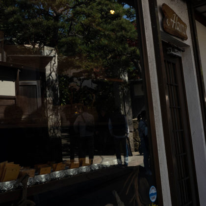 Entrance of a temple reflected in the window of a retro coffee shop